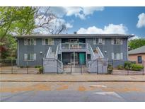 Charming apartment building with inviting turquoise doors, fenced front yard, and beautiful landscaping at 210 Sampson Ne St # 8, Atlanta, GA 30312