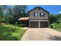 Inviting two-story home featuring a two-car garage and a well-manicured lawn, perfect for curb appeal at 1500 Country Ct, Auburn, GA 30011