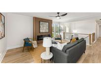 Bright living room with a modern fireplace, stylish furniture, and wood floors at 3152 Normandy Ne Cir, Marietta, GA 30062