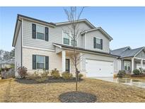 Charming two-story home featuring a two-car garage, white brick accents, and a well-maintained front yard at 4929 Dufour Dr, Lilburn, GA 30047