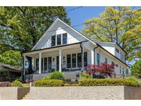 Charming two-story white home featuring black window trim, a covered porch, and well-maintained landscaping at 1076 Manigault Se St, Atlanta, GA 30316