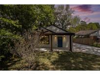 Charming home featuring a blue front door, wooden posts, manicured lawn, and a long driveway at 1189 Gardenia Nw St, Atlanta, GA 30314