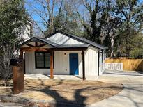 Charming renovated cottage with a bright blue front door and black trimmed windows at 1189 Gardenia Nw St, Atlanta, GA 30314