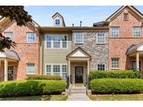 Charming townhouse exterior with a mix of stone, brick, and green wood facade at 1261 Ashford Creek Ne Park, Brookhaven, GA 30319