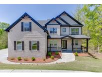 Beautiful home with a brick facade, dark shutters, gabled roof, and inviting front porch at 4208 Sierra Creek Ct, Hoschton, GA 30548