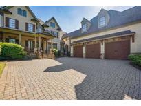 Charming home featuring a stone-paved driveway leading to a three-car garage and inviting covered entryway at 5473 Heyward Square Pl, Marietta, GA 30068