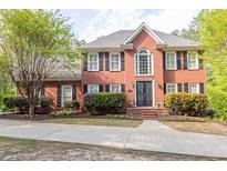 Stately brick home with meticulously landscaped front yard and inviting double door entrance at 1459 Harris Rd, Lawrenceville, GA 30043