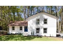 Charming two-story home featuring a manicured lawn and a striking blue front door at 185 Ansley Ct, Roswell, GA 30076