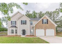 Inviting two-story home with a brick-accented two-car garage, complemented by a well-manicured lawn at 4500 Nocohoma Bnd, Douglasville, GA 30135