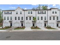 New townhomes with white siding, black trim, garage doors and landscaping at 148 Werner Brook Sw Way, Atlanta, GA 30354