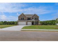 Charming two-story brick home with a well-manicured lawn and a three-car garage at 119 Felicity Pike, Locust Grove, GA 30248
