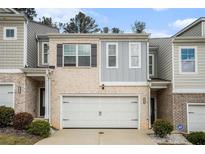 Charming townhome with brick and siding facade, featuring a one-car garage and well-maintained landscaping at 1868 Fabian Way, Austell, GA 30106