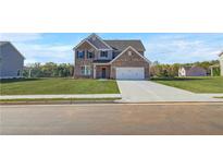 New two story brick home featuring a two car garage, well manicured lawn, and classic architectural design at 115 Felicity Pike, Locust Grove, GA 30248