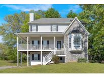 Charming two-story home features a covered porch, bay window, stone facade, and landscaped yard at 27 Friendship Rd, Euharlee, GA 30145