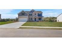 Inviting two-story home with a manicured lawn, brick and gray siding, and a spacious two-car garage at 123 Felicity Pike, Locust Grove, GA 30248