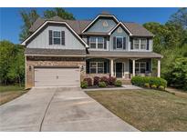 Charming two-story home with a brick-accented garage, inviting front porch, and meticulously manicured landscaping at 19 Four Feathers Ne Ln, Rydal, GA 30171