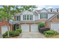 Charming townhome boasts a two-car garage, well-manicured landscaping, and a classic facade with neutral tones at 1491 Bellsmith Dr, Alpharetta, GA 30076