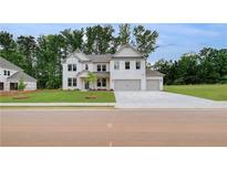 New construction featuring a brick facade, attached three-car garage, and a well-manicured front yard at 174 Haverling Pass, Hampton, GA 30252