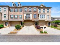 Charming brick townhome featuring attached garages and well-manicured landscaping, offering a welcoming curb appeal at 282 Autry Mill Ln, Suwanee, GA 30024
