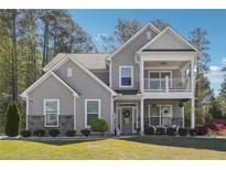 Charming two-story home with a welcoming front porch and well-manicured lawn at 2860 Windsor Knoll Dr, Dacula, GA 30019