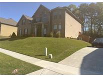 Attractive two-story brick home with a well-manicured lawn and paved driveway at 3798 Spring Place Ct, Loganville, GA 30052
