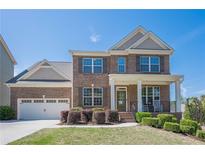 Charming two-story brick home with a well-manicured lawn and a classic front porch at 1060 Crescent Ridge Dr, Buford, GA 30518