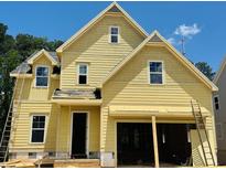 Charming yellow two-story home with a welcoming front door and attached two-car garage at 3350 Hillshire Dr, Cumming, GA 30028