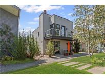 Modern home with a bright orange front door, balcony, landscaped yard, and stylish architectural details at 127 Ravenhurst Dr, Fayetteville, GA 30214