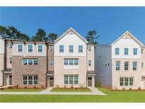 Charming multi-story townhomes showcasing brick and white siding with a well-maintained lawn at 3409 Catalan Aly, Decatur, GA 30032