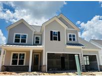 Charming new two-story home with a two-car garage and inviting front porch against a backdrop of blue sky and fluffy clouds at 3375 Hillshire Dr, Cumming, GA 30028