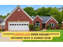 Charming single-story red brick home with a two-car garage and landscaped front yard at 1031 Ludwick Way, Lawrenceville, GA 30046