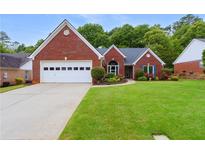 Charming single-Gathering home with a well-manicured lawn and a two-car garage, complemented by vibrant landscaping at 1031 Ludwick Way, Lawrenceville, GA 30046