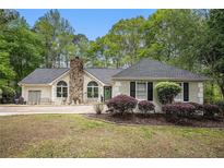 Charming single-story home featuring a stone chimney and well-maintained landscaping at 110 Emerald Dr, Mcdonough, GA 30253