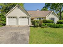 Charming ranch-style home with a two-car garage and well-manicured front lawn at 1220 Paddocks Way, Powder Springs, GA 30127