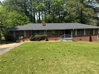 Charming one-story brick home featuring a well-maintained lawn and mature trees providing shade at 3137 Ardley Sw Rd, Atlanta, GA 30311