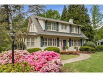 Charming two-story home with a landscaped front yard and a walkway leading to the front porch at 4220 Club Ne Dr, Atlanta, GA 30319