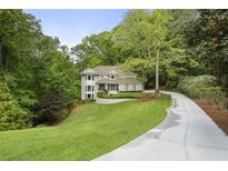 Stunning home with lush landscaping, a winding driveway, and mature trees providing great curb appeal at 660 Willow Knoll Se Dr, Marietta, GA 30067
