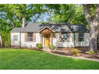 Charming home with a yellow door, shutters, and mature trees in a lush yard at 1611 Belmont Sw Ave, Atlanta, GA 30310