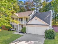 Charming two-story home featuring a well-manicured lawn, a two-car garage, and a welcoming front porch at 5223 Hollyfield Dr, Stone Mountain, GA 30088