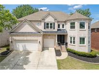 Charming two-story brick home featuring a well-manicured lawn, a two-car garage, and a welcoming entrance at 2311 Norbury Se Cv, Smyrna, GA 30080