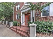 Inviting brick building entrance featuring a covered porch with brick stairs and elegant white pillars and railings at 733 Frederica Ne St # 2, Atlanta, GA 30306