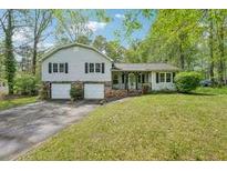 Charming home with a two-car garage, mature trees, and well-maintained lawn at 148 Sequoyah Cir, Canton, GA 30115