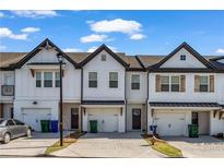 Charming townhome with white siding, black trim, and a one-car garage, creating an inviting curb appeal at 4142 Spring Valley Cir # 65, Tucker, GA 30084