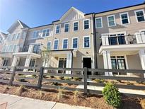 Beautiful townhome with brick and wood accents, a small front yard, and a black fence at 546 Sawnee Village Blvd # D71, Cumming, GA 30040