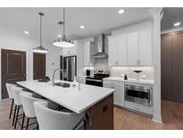 Modern kitchen with stainless steel appliances, an island with marble countertop and hanging lamps above it at 546 Sawnee Village Blvd # D71, Cumming, GA 30040