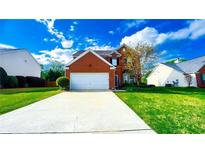 Charming two-story brick home with well-maintained landscaping and an inviting curb appeal on a sunny day at 2144 Beacon Crest Dr, Buford, GA 30519