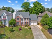 Charming two-story home featuring a well-manicured lawn and a spacious two-car garage at 2325 Walnut Grove Way, Suwanee, GA 30024