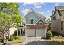 Charming two-story home featuring a brick and gray facade with a two-car garage and manicured landscaping at 3709 Baxley Ridge Dr, Suwanee, GA 30024