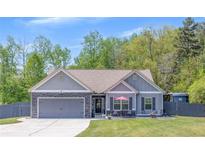 Charming single-story home with a manicured lawn, stone accents, and inviting front porch seating area at 12 Little Creek Manor Dr, Dallas, GA 30157