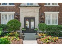 Elegant building entrance with ornate stone details, black double doors, and manicured landscaping at 20 Collier Nw Rd # 11, Atlanta, GA 30309